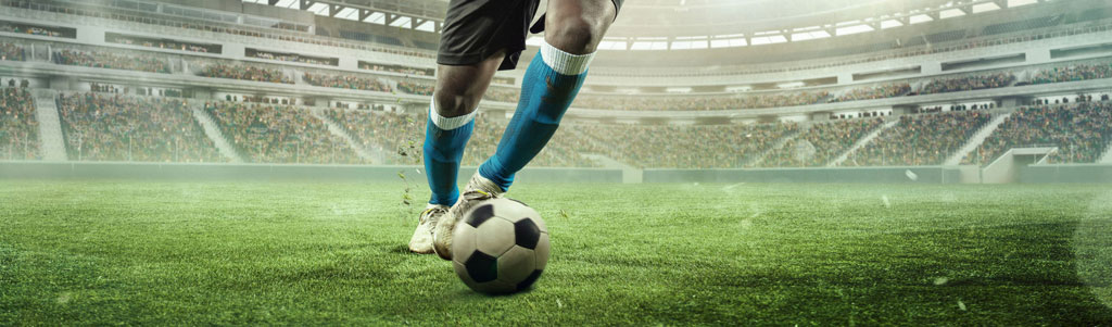 A footballer's legs, running with a ball